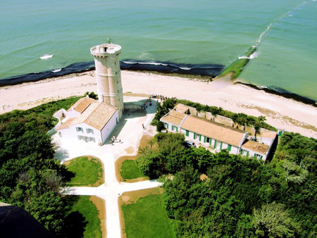 a lighthouse at the end of a peninsula in an islandの写真素材