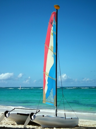 colorful catamaran boat on beach facing oceanの写真素材
