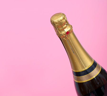 Bottle of champagne isolated on plain pink backgroundの写真素材