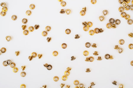 Spilled gold grommets isolated on white background