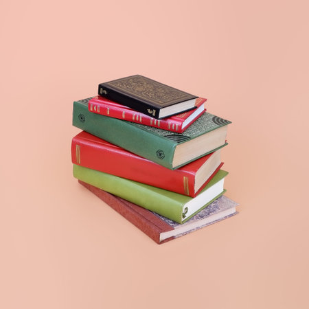 Stack of books in color covers with white sheets isolated on a pink background