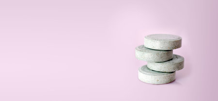 Green pills isolated on a pink background