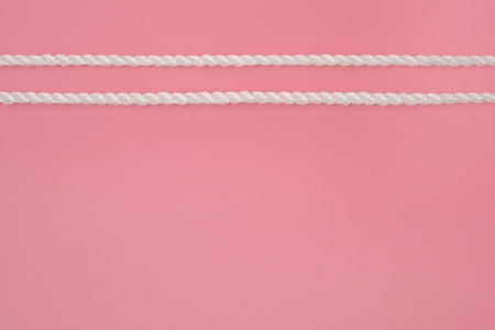 White silk rope isolated on pink background