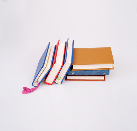 Stack of books in color covers with white sheets isolated on a white backgroundの写真素材