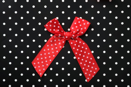 Silk bow isolated on a black background with white dotsの写真素材