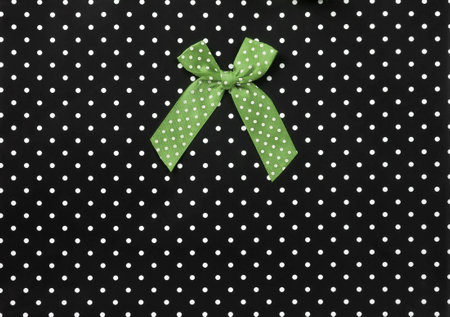 Silk bow isolated on a black background with white dotsの写真素材