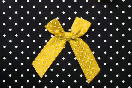 Silk bow isolated on a black background with white dots