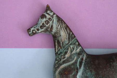 Composition with figurine of antique bronze horse isolated on a colored backgroundの写真素材