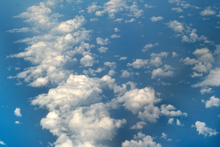 White clouds in the blue sky. Isolated view from airplane window
