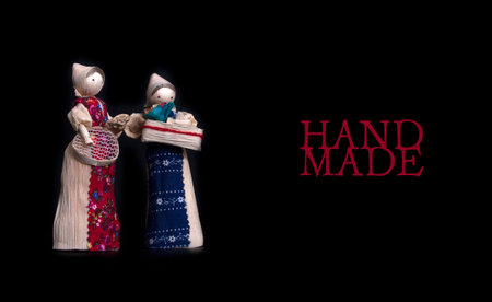 Set of straw souvenir dolls in national costumes isolated on black backgroundの写真素材