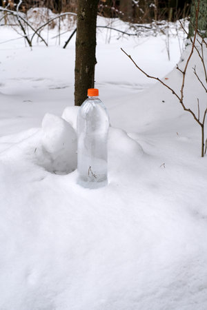A bottle of drinking water in the snow. advertising posterの写真素材