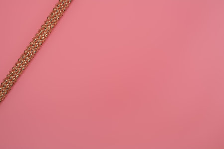 Gold necklaces isolated on a pink background