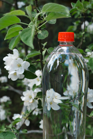 Water bottle in a blooming garden. Package designの写真素材