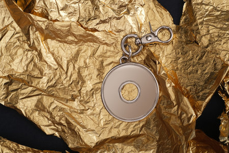 Round keychain with carabiner for bag isolated on golden background
