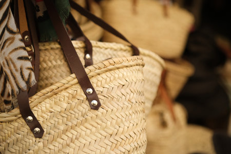 Summer women's handmade straw bags in a market showcase. Isolated image to create a backgroundの写真素材