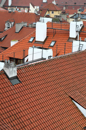 Aerial view of historic rooftops with terracotta tiles and white chimneysの写真素材