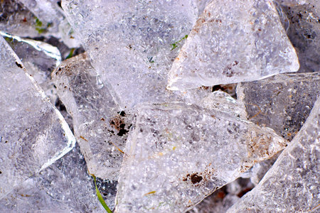 Ice fragments on frozen lake water level. The ice broken into shinning jagged pieces. Dark natural...