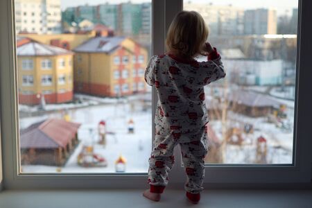 A little girl standing in front of a windowの写真素材