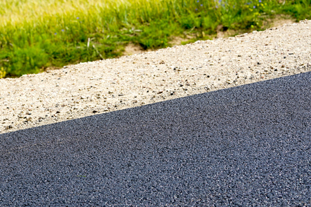 new asphalt, gravel roadside, green meadowの写真素材