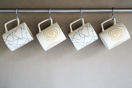 four cups with different ornament hanging in the kitchenの写真素材