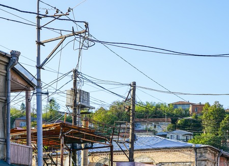 Old lighting post with many electric supply wires or cables for telephone communicationの写真素材