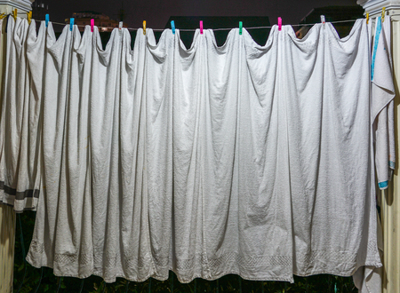 view of the household, white towels dries on ropes on clothespinsの写真素材