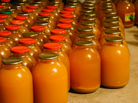 homemade apple juice in three liter glass jars in the house cellarの写真素材