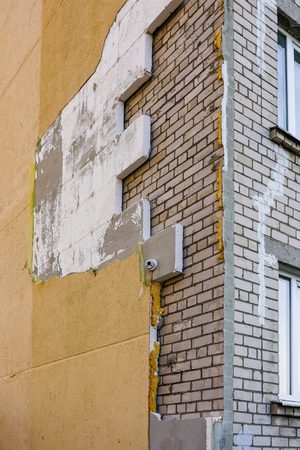 strong wind or poor quality of work damaged apartment building thermal insulationの写真素材