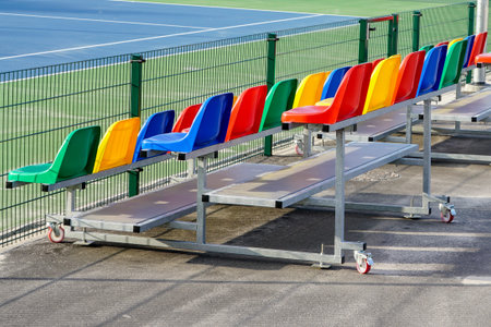 portable small size metal stands with colorful plastic seats for spectators in the stadium
