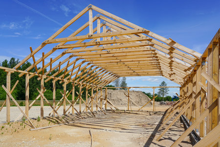 Frame of a new wooden house under construction, blue sky in the background
