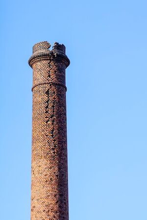 industrial heritage, dangerously crumbled and cracked red brick chimney in Liepaja, Latviaの写真素材