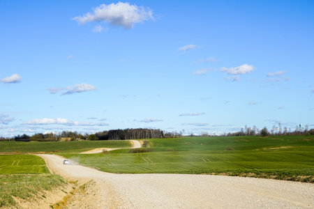 view of a winding scenic gravel road between the fieldsの写真素材