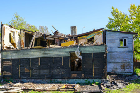 an old abandoned two-storey wooden house on a city street under demolition stage