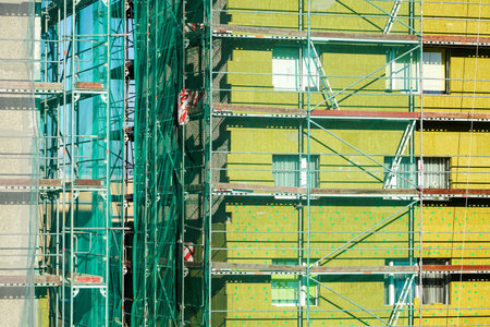 scaffolding arround the house to install thermal insulation of the apartment building facade, blue...