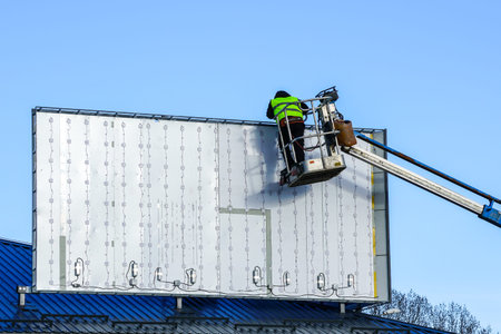 installation of a new large modern billboard with LED lighting on a background of blue skyの写真素材