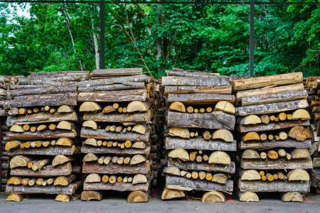 firewood stack, mostly made of halved tree trunks, neatly stacked alternately lengthways and crosswaysの写真素材