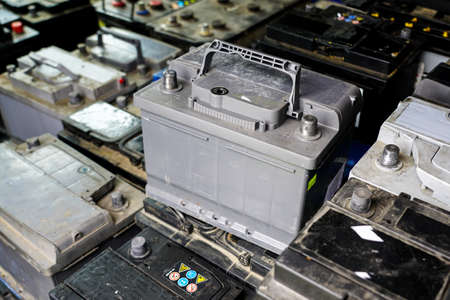 Pallet with used car batteries waiting to be recycled in an environmentally harmful scrap yardの写真素材