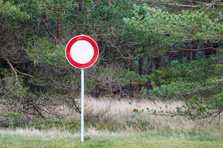 round red and white road sign is forbidden to drive on a green forest backgroundの写真素材
