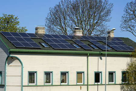 Many photovoltaic solar panels mounted on the old large wooden house roof, roof of solar panels