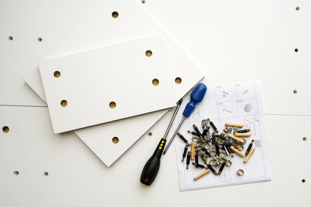 New white laminated chipboard furniture self mounting set with fitting screws, wooden pins, fastenings, screwdrivers and assembly diagramの写真素材