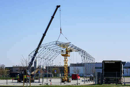 Installation of a polyvinyl chloride fabric cover for metal frame tent hangar using crane and lift