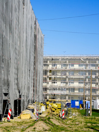 Multi storey apartment building facade renovation and thermal insulation works, scaffolding with...