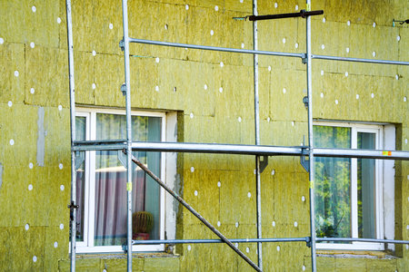 Thermal insulation of the facade of the residential house with thick rock mineral wool slabs using scaffoldingの写真素材