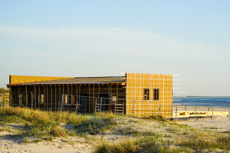 New unfinished natural wood cafe building framework and terrace floor on the Baltic seashore, blue sky backgroundの写真素材