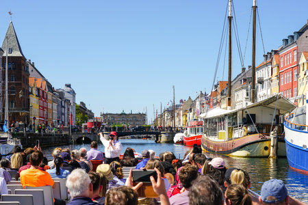 Copenhagen, Denmark- May 30, 2023: Nyhavn pier, colorful view from canal tour boat with many peopleのeditorial素材