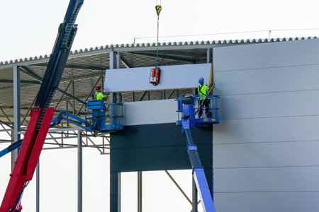 Sandwich panels wall assembly using telescopic boom crane and two self propelled articulating boom...