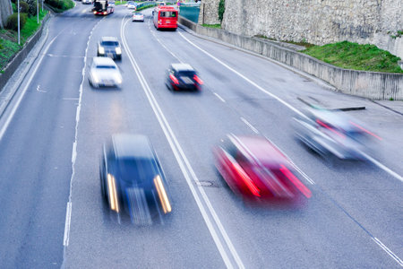 Abstract car traffic flow on a wide four-lane city street with blurred cars