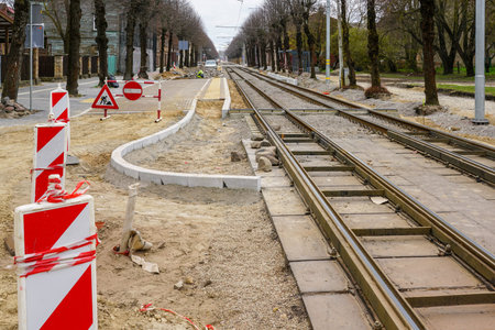 Unfinished construction of a modern low-floor tram stop and replacement of tram rails on a city streetの写真素材