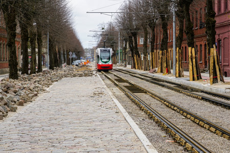 Perspective view of street reconstruction, tree trunks protection with board covers, newly replaced tram tracks and natural granite pavementの写真素材