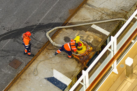 The process of mooring a large cruise ship with a rope at the harbor pier, pulling the rope ashore,...